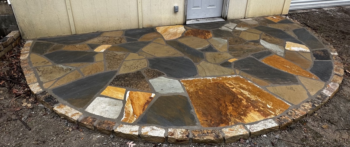 Colorful flagstone entry patio with a cobble border