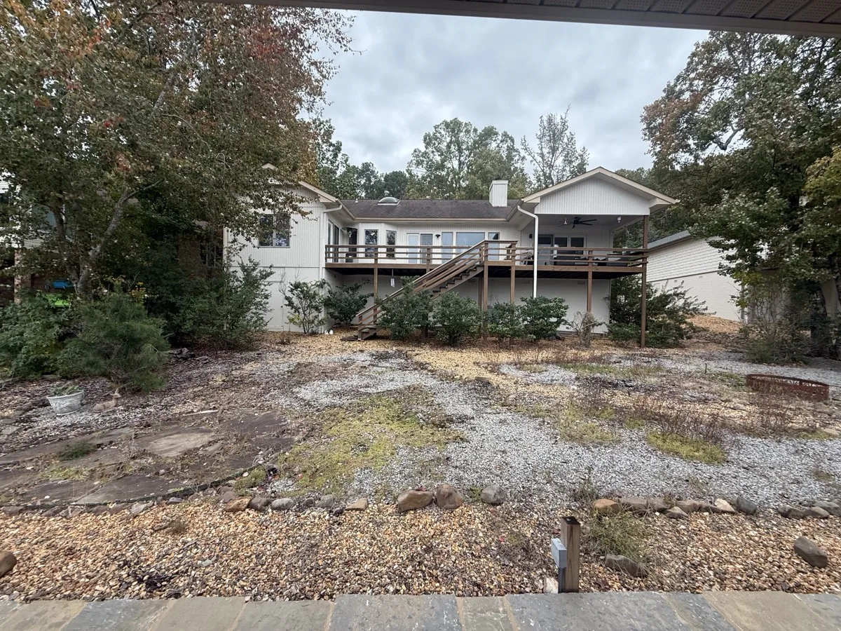 Backyard before — bare, rocky, unlandscaped slope